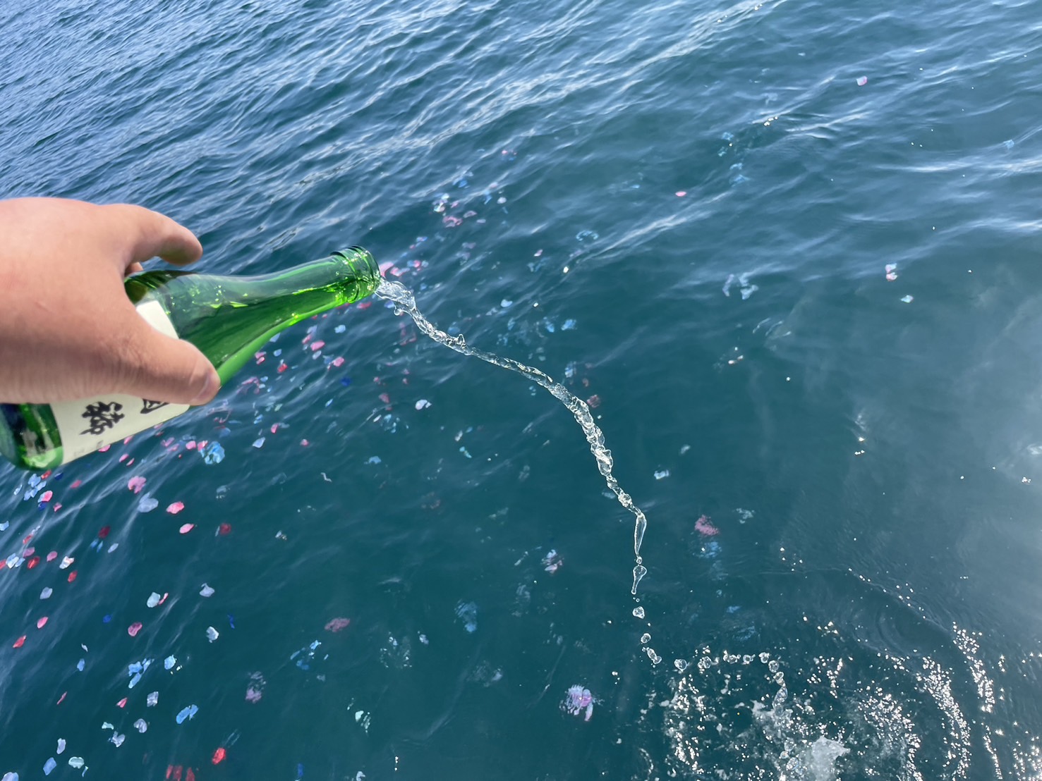 故人の好きだったお酒を海に注ぐ献酒