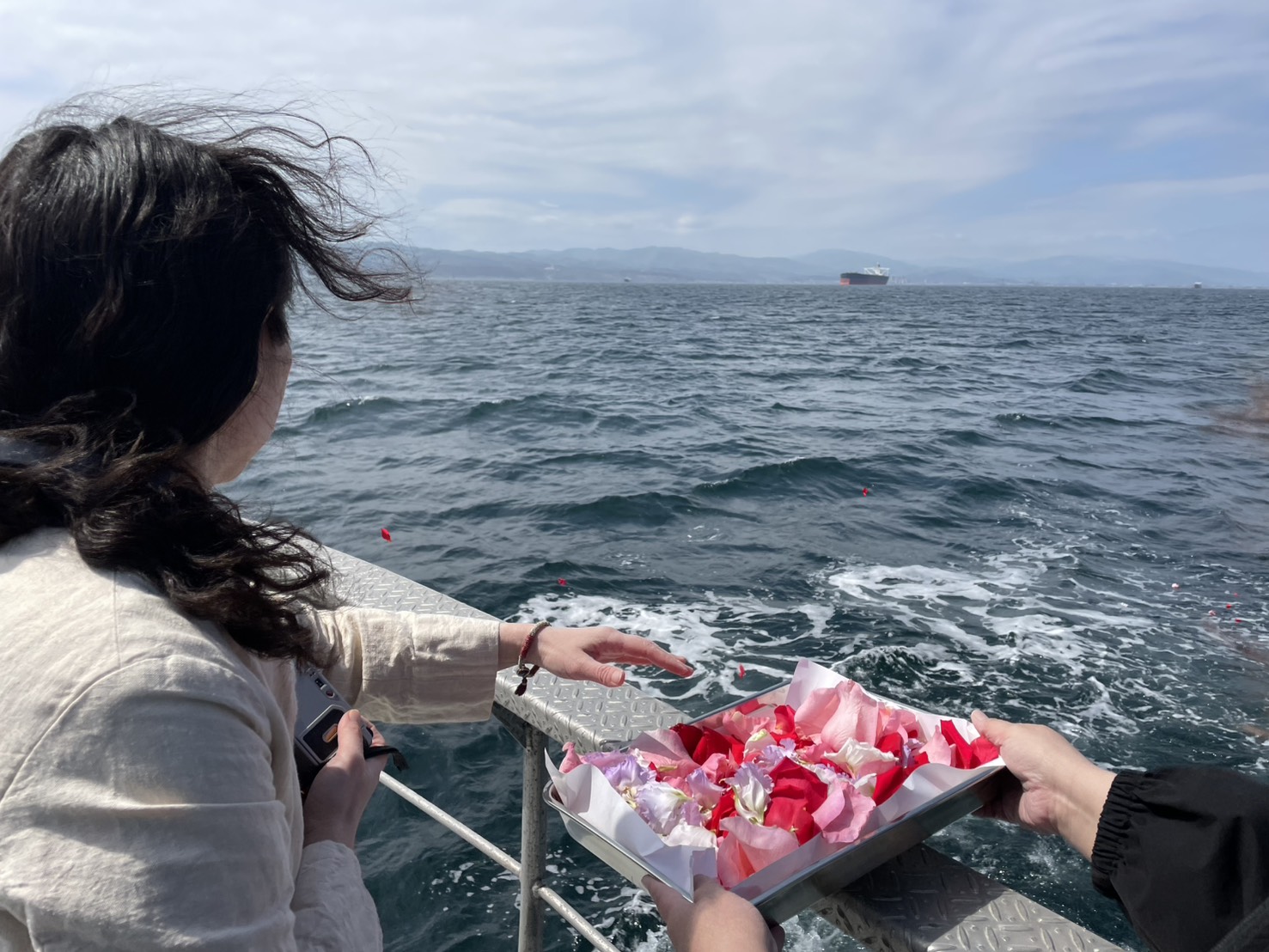 海に花びらを手向ける献花